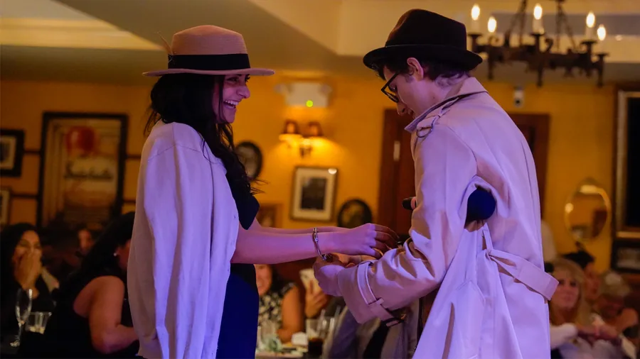 A Murder Mystery Company detective questioning a guest at a Detroit show